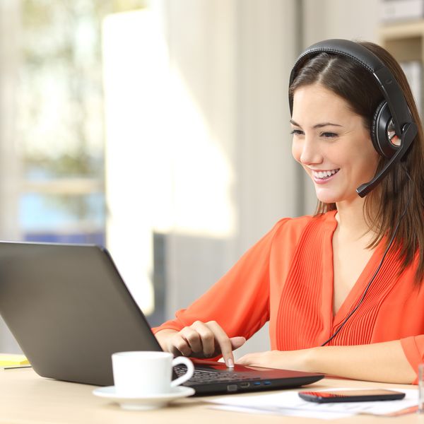 Operatrice di un fornitore di energia con cuffie davanti a un portatile
