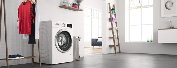 Bosch laisvai statoma skalbyklė moderniame baltame vonios kambaryje 