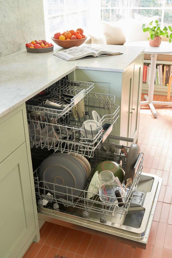 Dishwasher open in green and white kitchen