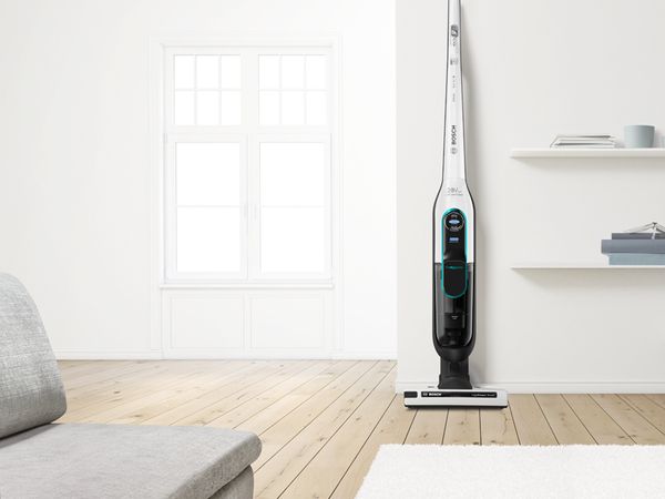Flexible Bosch Athlet ProHygienic cordless vacuum against a wall in a bright living room 