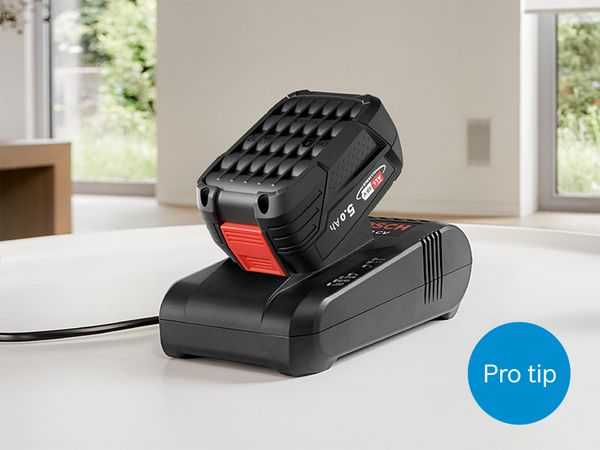 Powerful Bosch 18V battery charging in quick charger on a countertop