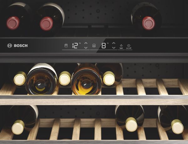 Le bandeau de commande digital d'une cave à vin avec deux zones de température : vin rouge sur les étagères du dessus, vin blanc sur les étagères du dessous.