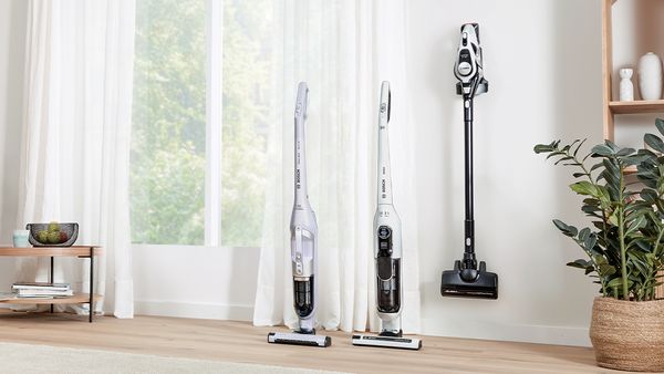 Lineup of cordless vacuum cleaners in a living room.