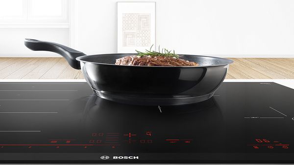 Meat cooking in pan on induction hob