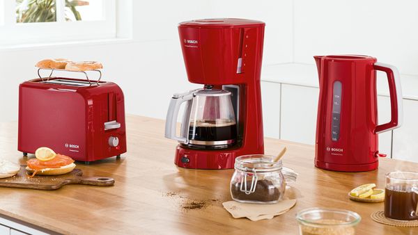 Zestaw CompactClass obejmujący czajnik, ekspres do kawy i toster w kolorze czerwonym. 