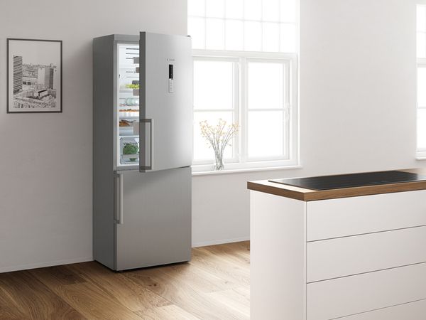 Moderna cocina blanca con refrigeradora, campana extractora, encimera y marca europea Bosch Nr. 1 premio.