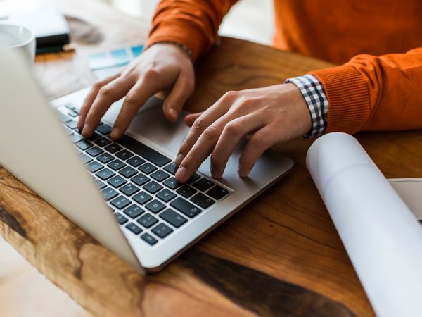 Mani di ragazzo che digitano sulla tastiera di un portatile