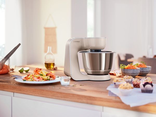 Witte MUM5 keukenmachine in de keuken met zoete en hartige hapjes.