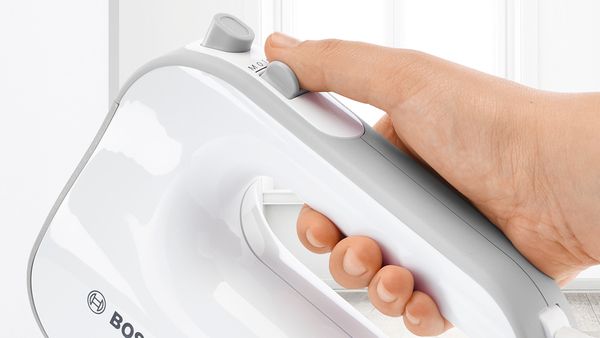 Zbliżenie na rękę trzymającą mikser ręczny marki Bosch z powłoką SoftTouch zapewniającą pewny chwyt.