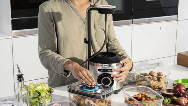 A Bosch blender being used to vacuum seal compatible containers.