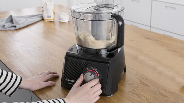A Bosch food processor on a worktop being used to make hummus.