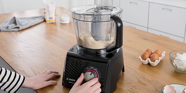 Making dough in a Bosch food processor. Ingredients on the worktop.