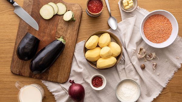 Ingredienti e istruzioni per preparare la moussakà di melanzane e lenticchie rosse.