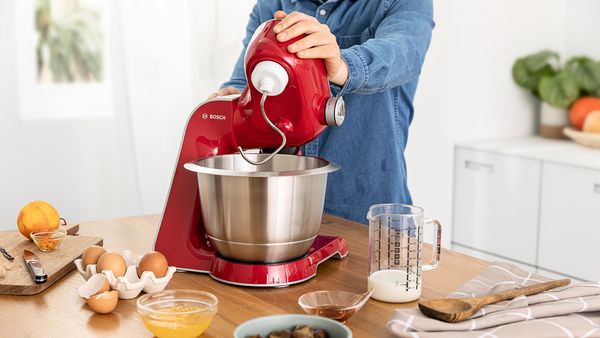 Impasta uova, latte e altri ingredienti con un robot da cucina Bosch.