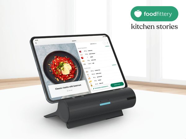 Tablet sat in smart dock on kitchen countertop with foodfittery logo