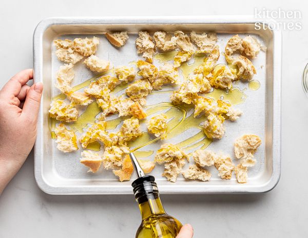 Drizzling olive oil onto bread pieces