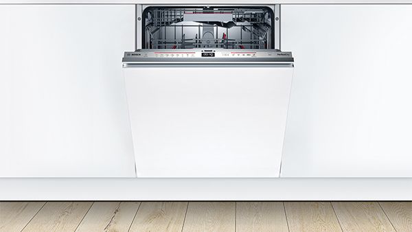 Máy rửa chén tích hợp đầy đủ trong nhà bếp màu trắng hiện đại với cánh cửa hơi hé mở.