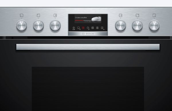 A Bosch electric hob with physical knobs for control, located together with the oven buttons.