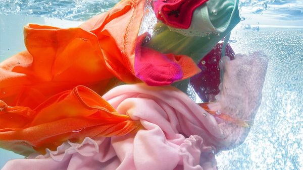 Farbenfrohe, empfindliche Textilien in Bewegung unter Wasser.