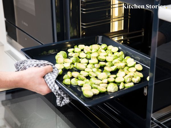 Placing halved brussels sprouts into oven