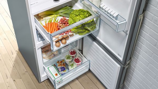 Angled overhead view of fridge with drawers open showing food contents inside