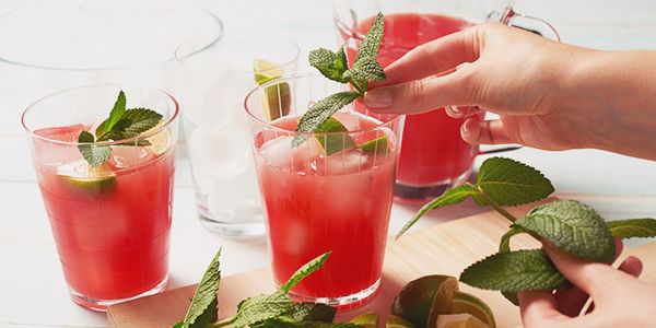 Bicchieri di succo di anguria con rametti di menta fresca.   