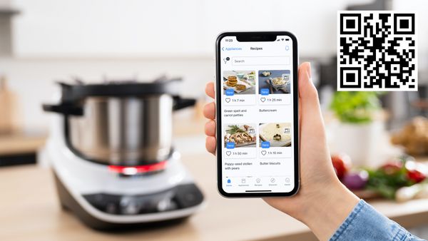 Utilisateur parcourant des recettes sur l'application Home Connect, avec le Cookit Bosch en arrière-plan.