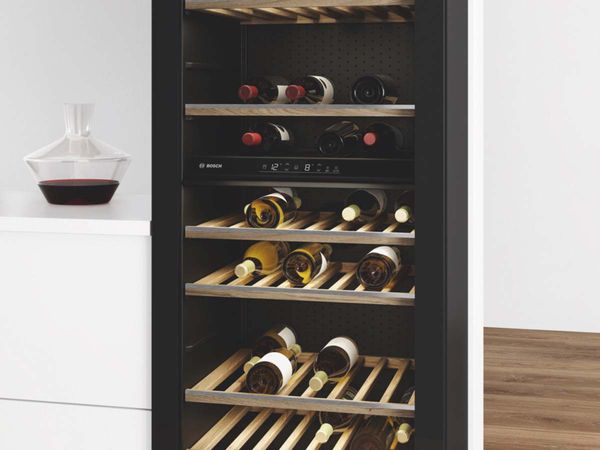 Vitrină de vinuri independentă, cu șase rafturi, ușă de sticlă, iluminare LED și o colecție de vinuri roșii și albe.