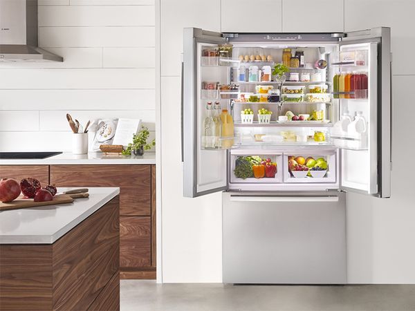 Réfrigérateur encastrable de Bosch 60 cm porte ouverte avec vue sur les provisions et boissons à l'intérieur