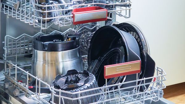 Accessoires Cookit chargés dans le panier inférieur du lave-vaisselle.