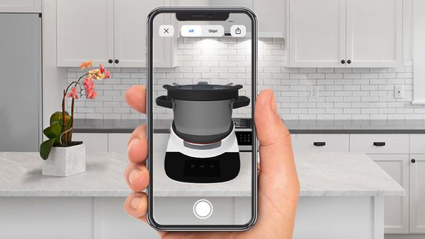 Using the Bosch AR feature to point and place the Cookit in a white, modern kitchen. 