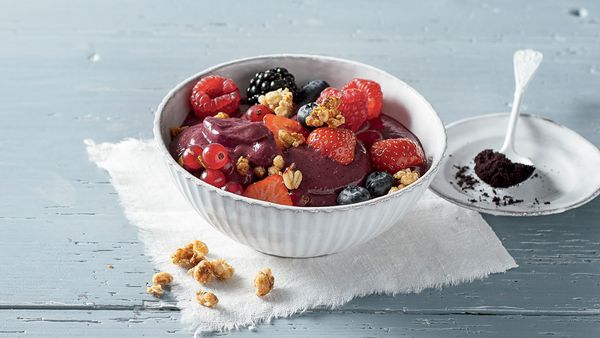 Bowl filled with a frozen cream and sprinkled with fresh berries and granola.