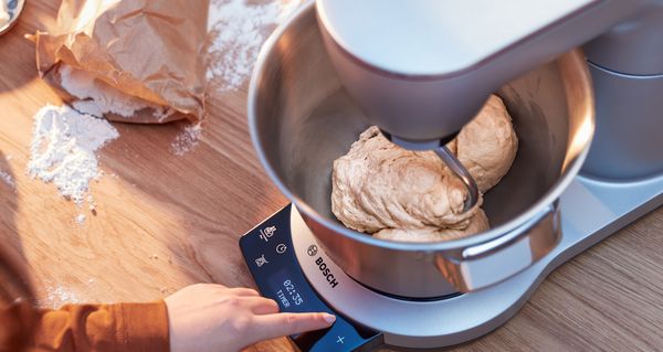 An advanced MUM Series 8 stand mixer with a timer and scale that's kneading dough.