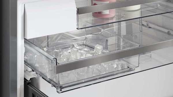 freezer of a french door fridge with opened ice cube compartment.