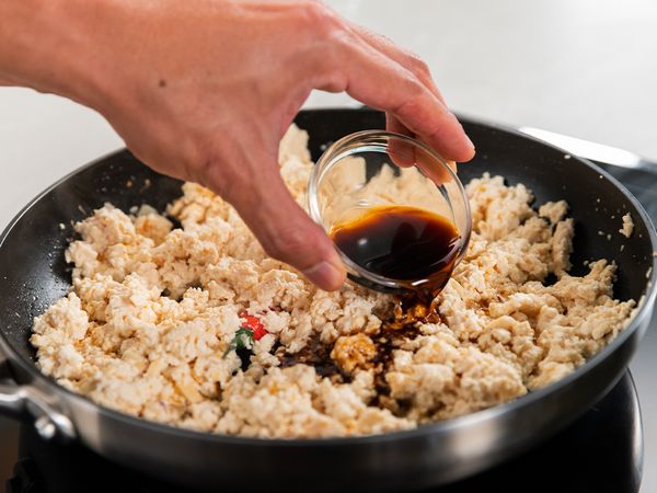 4. Add mashed bean curd, sesame oil, vegetarian oyster sauce, dark soy sauce, light soy sauce and cook for about 3 minutes. Throughout the frying process, add remaining oil should the pan get too dry. Season with salt and pepper and set aside.