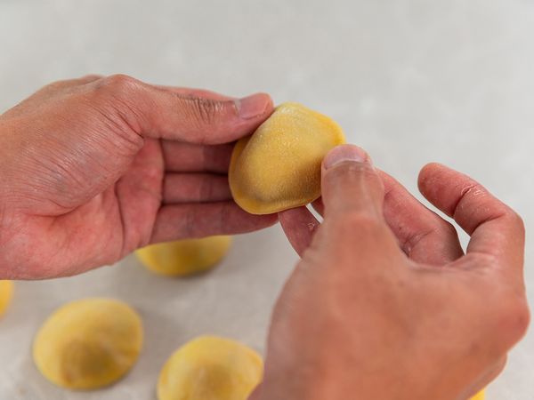 7. Press around the fillings so they remain in place. Cut Ravioli out with ring mould. Press along edges of Ravioli to seal. Repeat for the other pasta sheets and set Ravioli aside. Fill ¾ of a medium-sized pot with water and bring to boil. Boil Ravioli for about 2 to 4 minutes to your desired texture. Set aside 3 tablespoons of pasta water for later use. Remove Ravioli from pot.