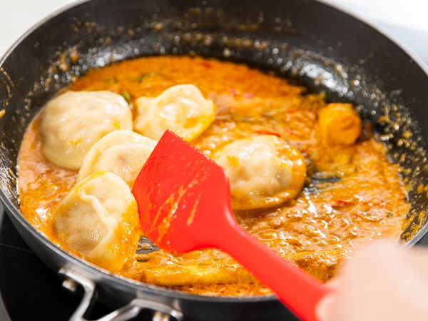 9. Add whipping and coconut cream. Simmer for about 5 minutes. Add Tom Yum paste. Continue frying for about 1 minute. Add pasta water to achieve your desired sauce consistency. Add Ravioli and toss. Season with salt and pepper.
