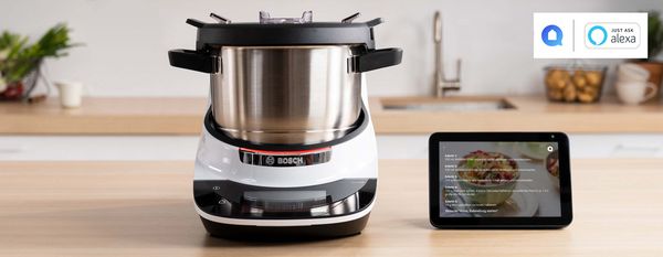 Der Cookit auf einer Küchenarbeitsplatte neben einem Smart Speaker mit Touchscreen