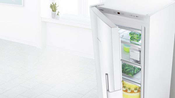 Hvitt frittstående apparat med døren litt åpen for å vise fleksible oppbevaringsalternativer.