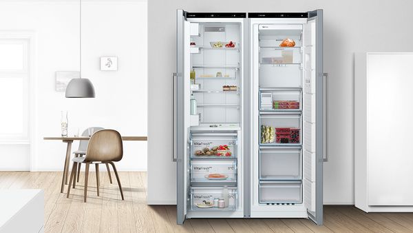 Un réfrigérateur et un congélateur pose-libre jumelés et ouverts pour créer une combinaison de réfrigérateur-congélateur.