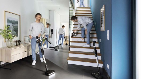 Um homem limpa as diferentes partes da sala e escada com o flexível Unlimited. .