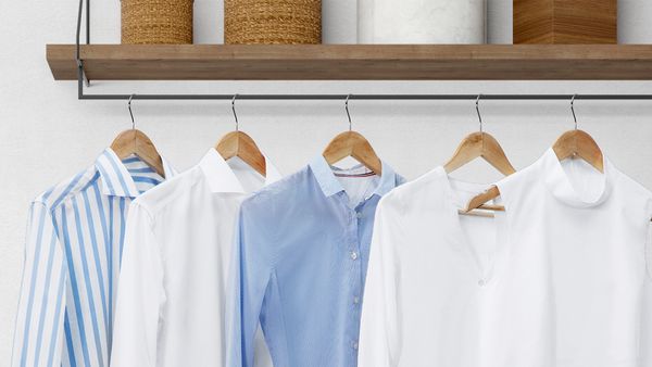Une rangée de chemises blanches et bleues fraîchement repassées.