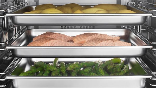 A stainless steel refrigerator with two trays filled with food, providing ample storage for perishable items.