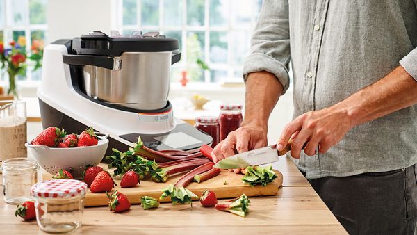 Bosch Cookit K&uuml;chenmaschine mit Kochfunktion beim Vorbereiten frischer Zutaten in der K&uuml;che.