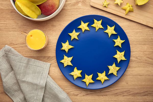 Le drapeau européen orné d'une assiette et de fruits.