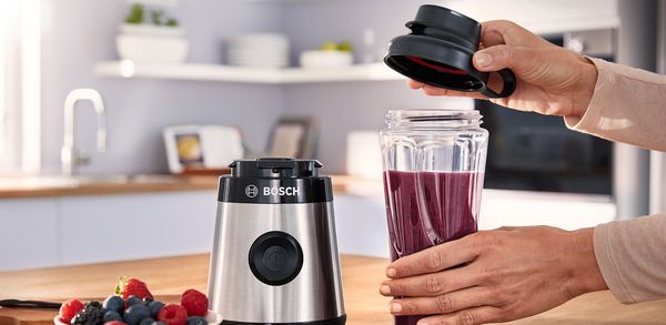 The Bosch Miniblender VitaPower Series 2 is being opened by a women.