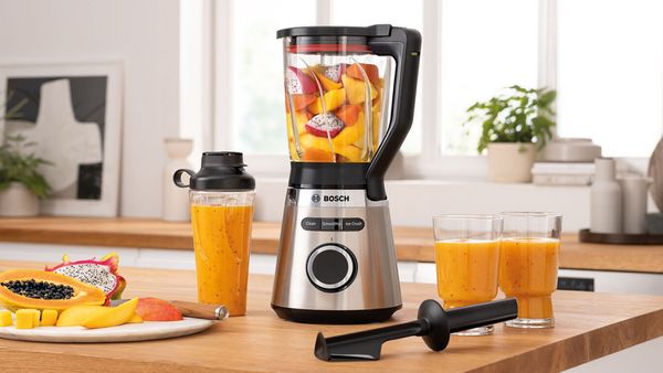 Bosch Blender VitaPower Series 4 with fruits, To-Go-Bottle and smoothie glasses on a kitchen shelf.