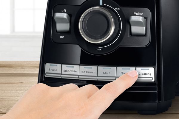 Osoba pritiska dugme za čišćenje na Bosch blenderu visokih performansi VitaBoost da bi pokrenula program čišćenja.