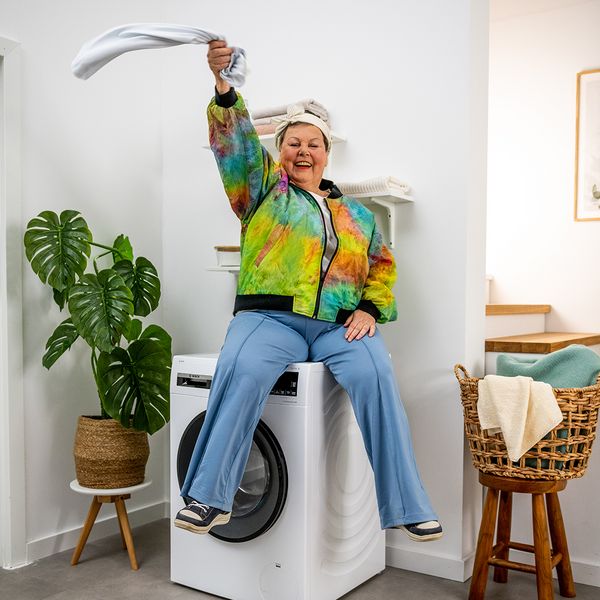 Woman sitting on top of laundry machine