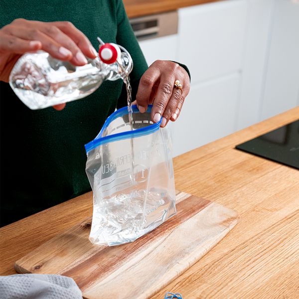 Pouring white vinegar into ziplock bag
